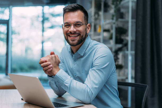 Professional in a modern office with a laptop.